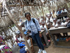 Students in classroom with teacher, founder Light Up A Village in DRC